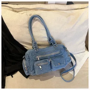 Detailaufnahme einer stylischen Jeans-Umhängetasche mit mehreren praktischen Reißverschlüssen.