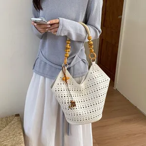 Elegante weiße perforierte Beuteltasche mit Holzperlen-Griff für stilvolles Pendeln im Alltag.