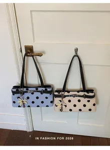 Vue détaillée de l'élégant sac à l'épaule à pois avec charmant pendentif palmier et surpiqûres.
