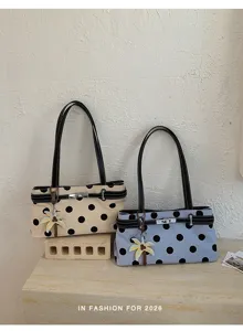 Vue détaillée du sac à épaule élégant à pois avec serrure métallique et charm palmier.