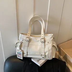 Vista dettagliata della borsa tote da donna bianca con doppi manici e fibbie in metallo.