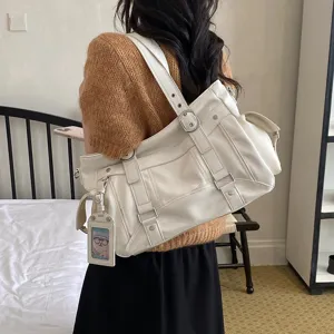 Vista dettagliata della borsa a spalla in pelle PU bianca con fibbie eleganti e grande capienza.