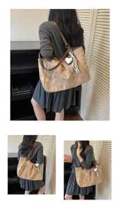 Detail view of a vintage canvas tote bag with leather straps, side zip pocket, and cute heart charm.