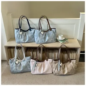 Detailed lifestyle view of fashion tote bags with heart charm and spacious interior design.