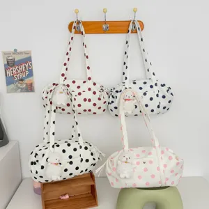 Vista dettagliata della borsa a tracolla a pois con simpatico ciondolo coniglietto di peluche.