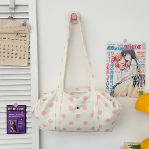 Dettaglio borsa shopper a tracolla in tela a pois rosa con design di borsa casual alla moda.
