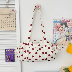 Vista dettagliata di una borsa a tracolla casual in tela bianca con pois rossi alla moda.