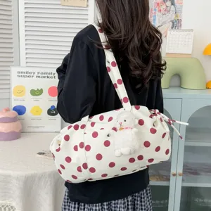 Vista dettagliata della borsa a tracolla a pois casual con un grazioso ciondolo in peluche.