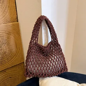 Detailed shot of brown woven mesh shoulder bag, minimalist macrame texture and style.