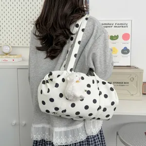 Vista dettagliata della borsa a tracolla a pois alla moda da donna con ciondolo pecora di peluche.