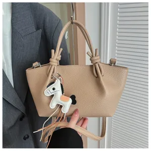 Sac à main minimaliste en cuir avec poignées nouées élégantes et charmant petit cheval.