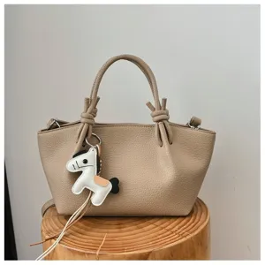 Sac à bandoulière en cuir minimaliste pour femme, élégant sac seau avec charmant pendentif cheval.