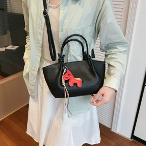 Sac seau minimaliste en cuir noir avec charm cheval rouge, élégant sac bandoulière élégant.