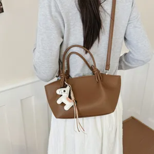 Élégant sac à bandoulière en cuir marron, sac seau minimaliste avec charmant pendentif cheval.