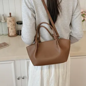 Sac porté épaule en cuir marron pour femme, design minimaliste élégant avec nœud.