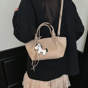 Sac à main bandoulière minimaliste pour femme avec pendentif cheval pour un look élégant.