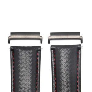 Detailed close-up of textured black leather watch strap with red stitching and metal connectors.