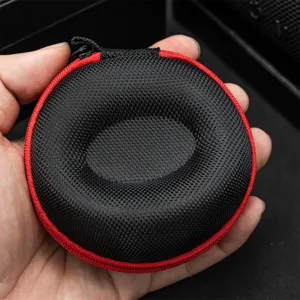 Portable round watch storage box detail view, black woven hard shell case with red zipper closure.