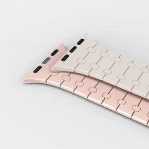 Vue détaillée du bracelet de montre magnétique en silicone rose et beige, maillons lisses.