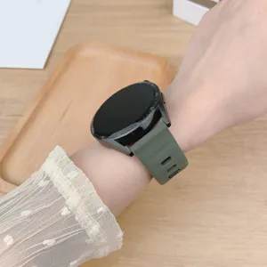 Close-up of military green silicone watch strap on wrist, showing texture and breathable holes.