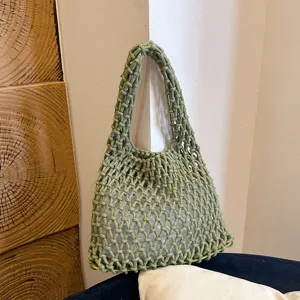 Green woven mesh shoulder underarm bag detail, minimalist handmade rope handbag.