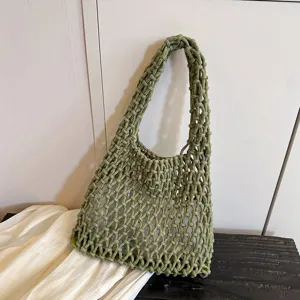 Green woven shoulder bag detail, stylish mesh design, chic underarm purse close up.