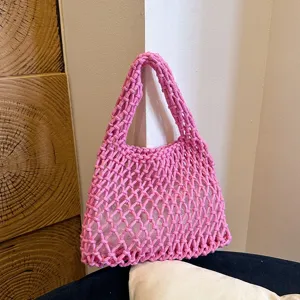 Close-up detail of the pink woven mesh shoulder handbag showcasing its delicate crochet texture.