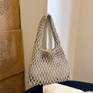 Detailed view of handmade woven mesh underarm bag, minimalist rope shoulder bag for women.