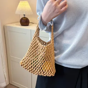 Detail shot of a minimalist beige woven mesh shoulder bag, highlighting its stylish net texture.