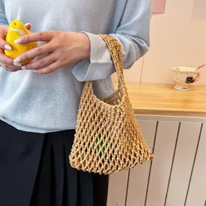 Woven net shoulder bag detail view, casual straw bucket bag close-up design style.