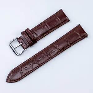 Vue détaillée d'un bracelet de montre en cuir marron avec texture croco et boucle ardillon.