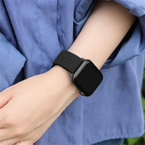 Close-up detail of the black braided nylon watch strap worn on wrist, soft stretchy texture.