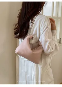 Detailaufnahme der modischen rosafarbenen Schultertasche mit eleganter Metallkette und Leder.