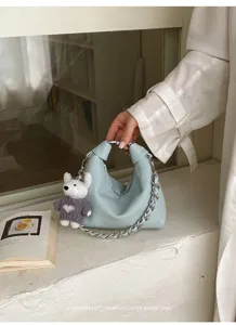 Detailansicht der hellblauen Umhängetasche mit grober Kette und süßem Bärenanhänger.