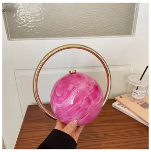 Pink marble spherical handbag with gold ring handle, elegant chic evening bag for women.