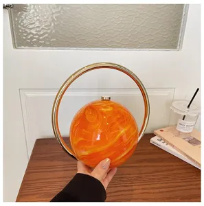 Orange marbled spherical evening handbag with luxury metal ring handle for women commute fashion.