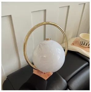 Exquisite marble pattern round handbag, elegant gold metal ring handle, chic evening bag detail.