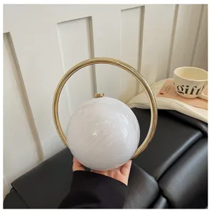 Close-up detail of the stylish white marble round evening bag with a luxury gold ring handle.