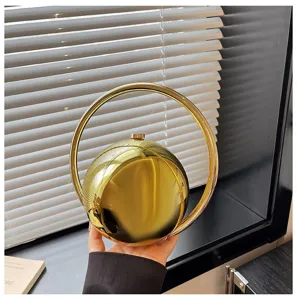 Golden metallic spherical handbag with round handle, chic evening clutch and fashion purse.
