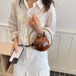 Chic round wooden texture handbag with metal ring handle, elegant evening bag for women.