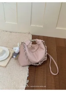 Schicke rosa Leder-Hobo-Umhängetasche mit Silberkette und niedlichem Plüsch-Anhänger Detail.