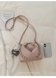 Nahaufnahme der eleganten rosa Leder Handtasche mit Metallkettenhenkel und Schulterriemen.