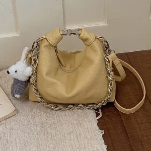 Elegante Damen gelbe Leder Knödel Umhängetasche mit Metallkette und süßem Bären-Anhänger.