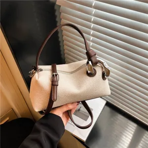 Sac à main bandoulière décontracté et tendance avec design oreiller et lanières contrastées.