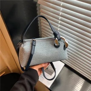 Vue détaillée du sac oreiller texturé gris élégant avec des lanières bleues et des anneaux en métal.