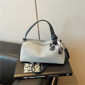Vue détaillée d'un élégant sac bandoulière gris tendance avec poignée en cuir noir.
