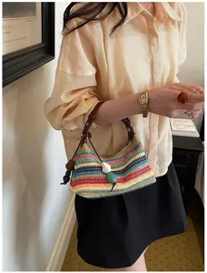 Detailaufnahme der bunten Stroh-Schultertasche mit einzigartigem Streifendesign und Ledergriff.