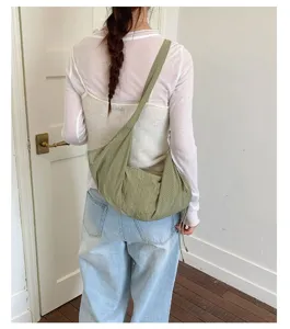 Green checkered canvas shoulder bag worn on shoulder, showing casual slouchy design and details.