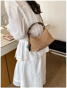Sommer Stroh Schultertasche Detail, stilvolle gewebte Hobo Tasche mit braunem Ledergriff.