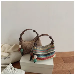 Detailansicht der sommerlichen Stroh-Schultertasche mit bunten Streifen und natürlicher Textur.
